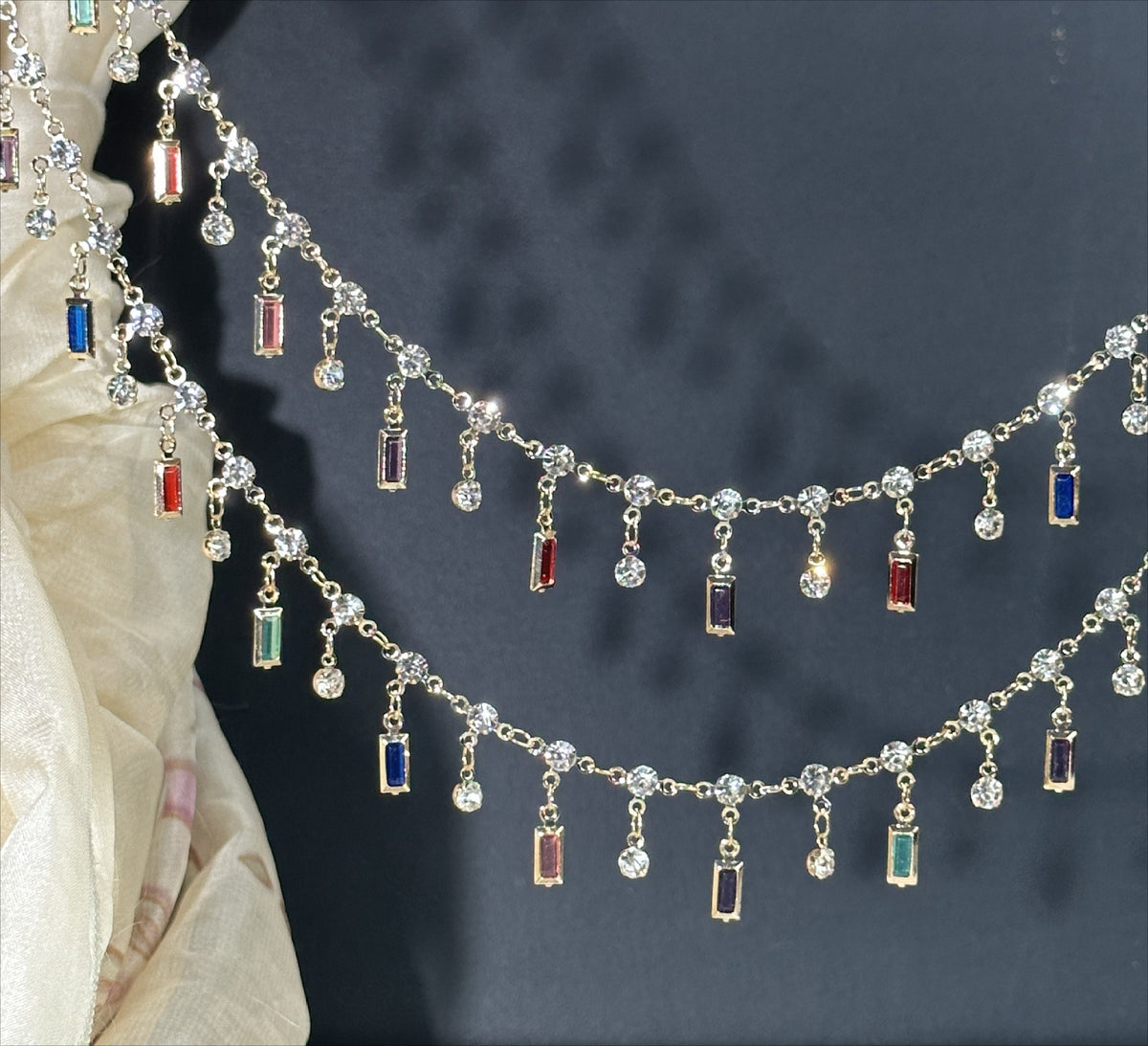 Gold-tone chain garland with dangling rectangular and round clear stones and small colored accents