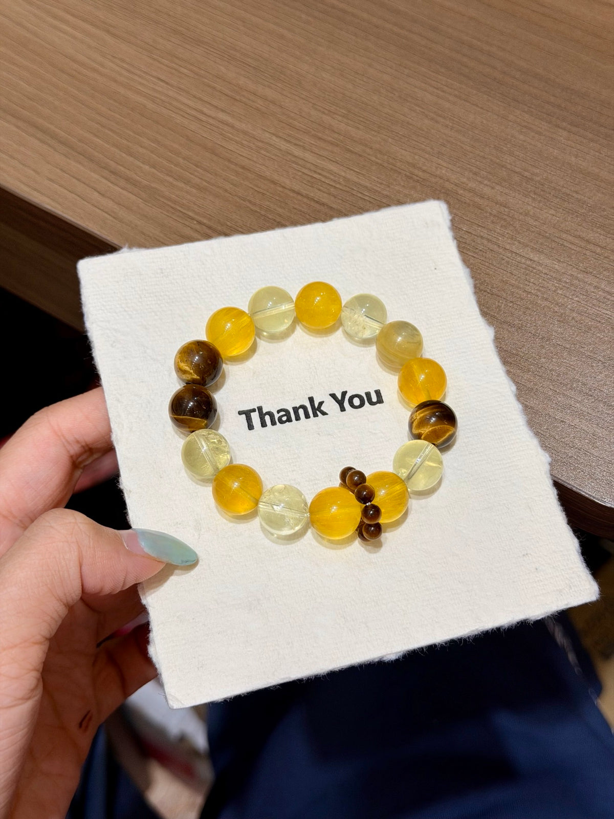 Golden wind bracelet with tiger's eye runner rings on mirror tray