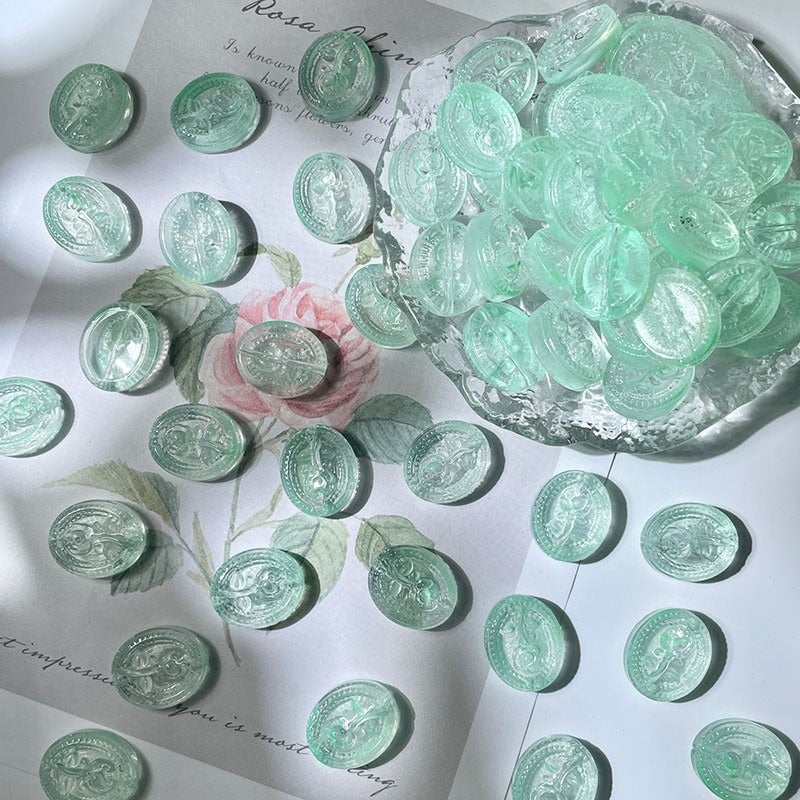 Light green translucent engraved glass beads scattered on white
