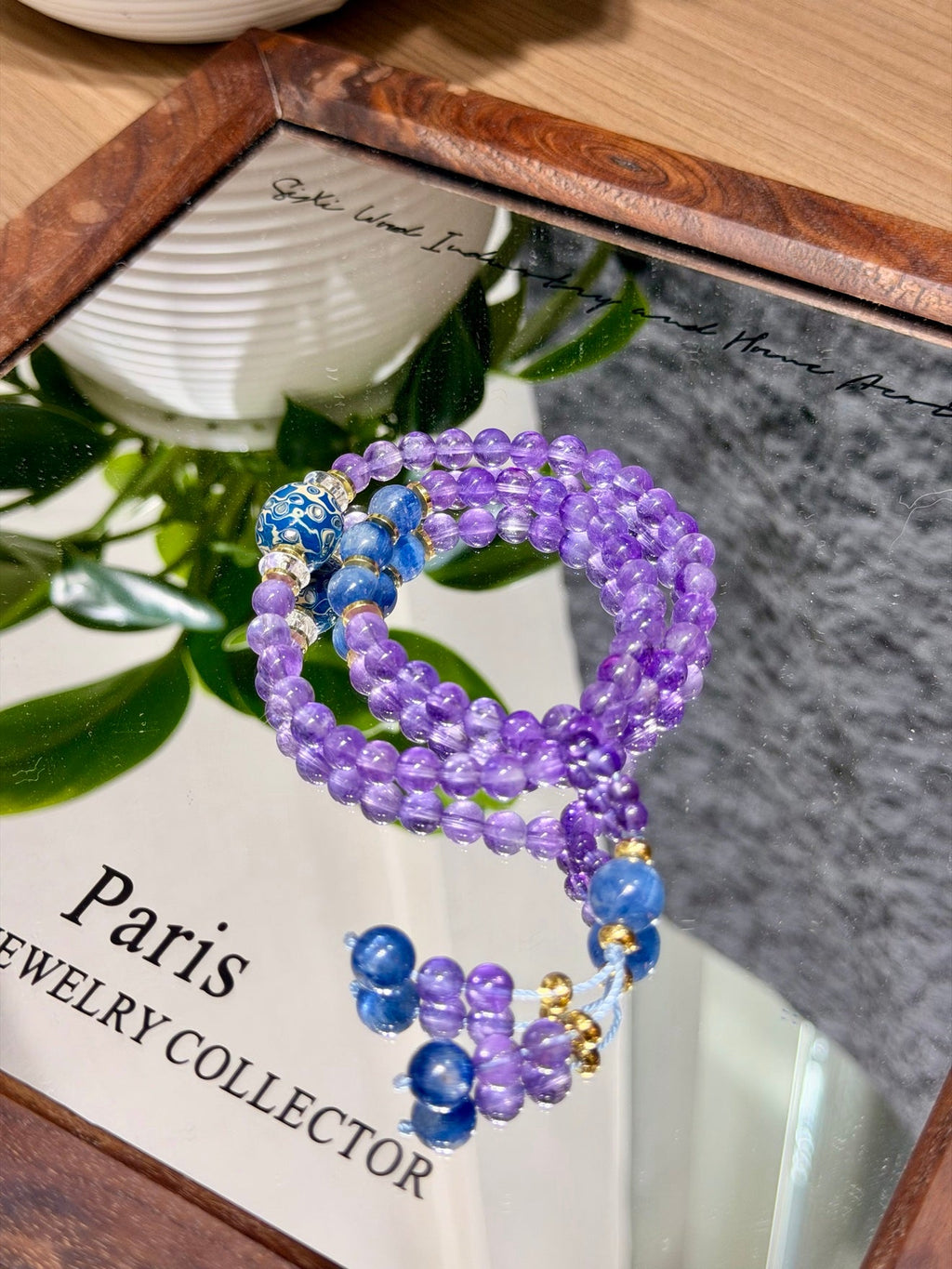 Purple amethyst double-loop bracelet coiled on mirrored wooden tray